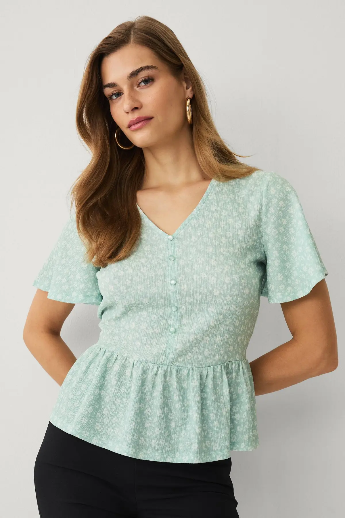Jerseybluse med volang Grønnblomstret